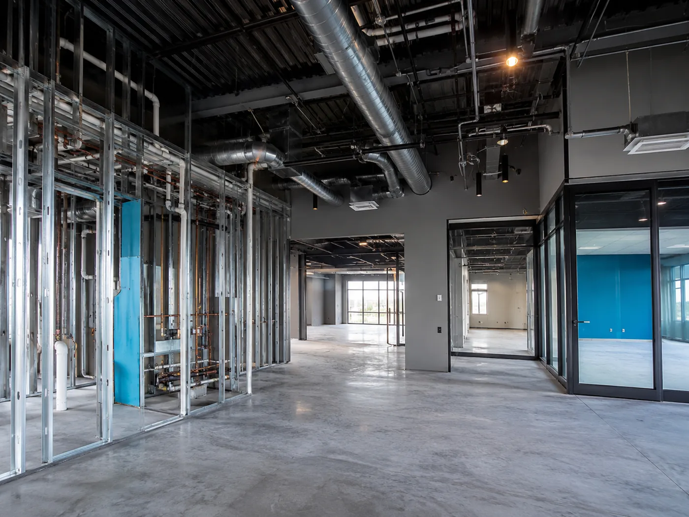 Industrial warehouse conversion with visible plumbing and mechanical systems